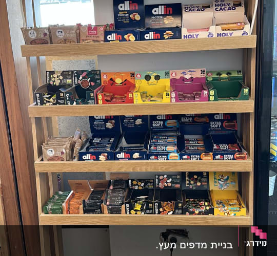 מדף עץ עם מוצרים שונים, כולל חטיפי חלבון